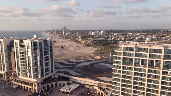 A flight between high points to the sea with the beach and tourists in the town of Herzelia in Israe