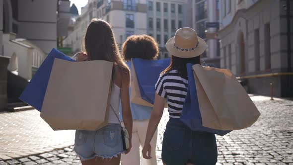 Back View of Women Putting Paper Bags on Shoulder