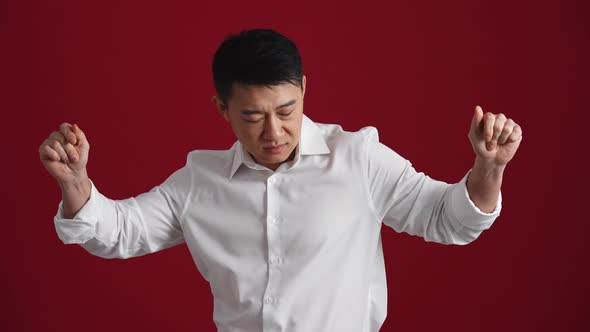 Cheerful Asian man in white shirt dancing