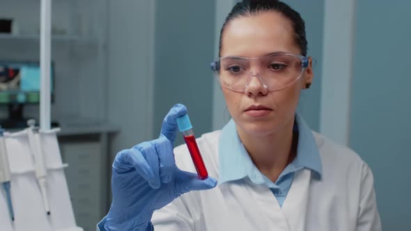 Portrait of Chemist Holding Glass Vacutainer with Blood