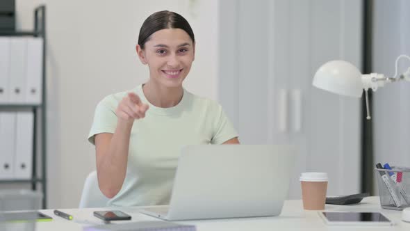 Young Latin Woman with Laptop Pointing at the Camera