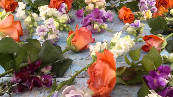 Colorful summer garden flowers: dragon flowers, roses, sweet pea on the vintage wooden