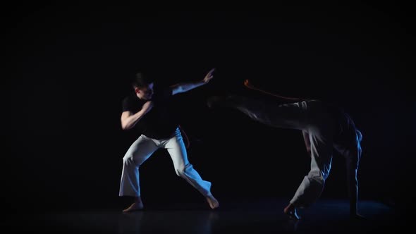 Two Males Are Performing Complex of Martial Art of Capoeira. Slow Motion