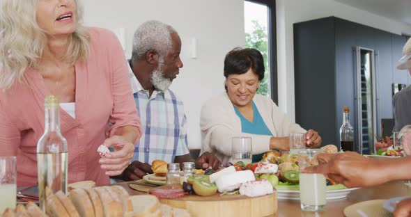 Happy senior diverse people having dinner at retirement home