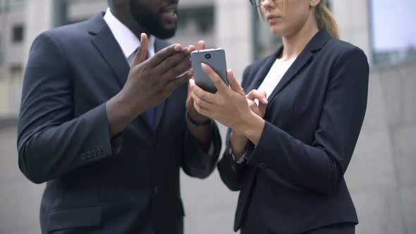 Colleagues Discussing Useful Application in Smartphone for Business People