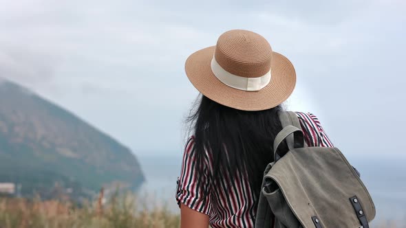 Rear View Elegant Woman Traveler with Backpack Walking on Mountain Peak Admiring Nature Landscape