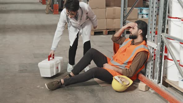 Female Doctor Treating Sick Warehouse Worker