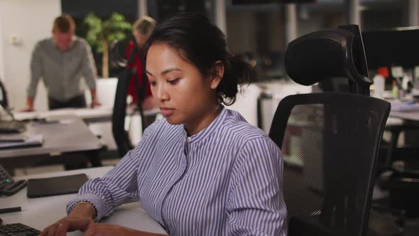 Professional businesswoman using computer while sitting on her desk in modern office in slow motion