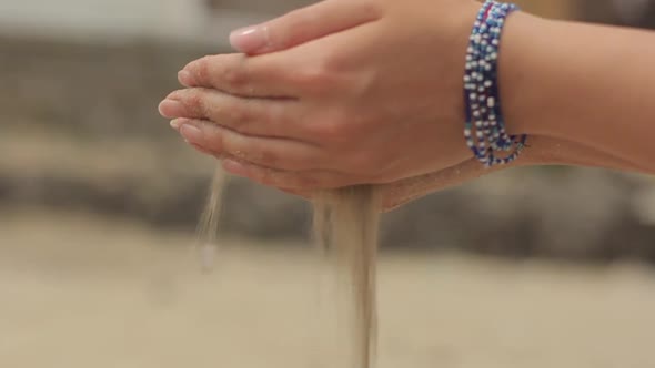 The Sand Is Poured Out of Female Hands