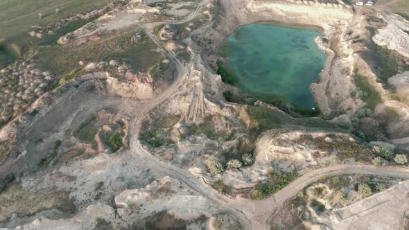 Aerial Drone Footage of a Small Rock Quarry Flooded Into a Small Lake