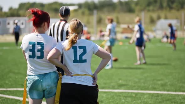 Silhouette of Women Watching the Game on the Green Grass in the Field. Athletic Female Team Playing