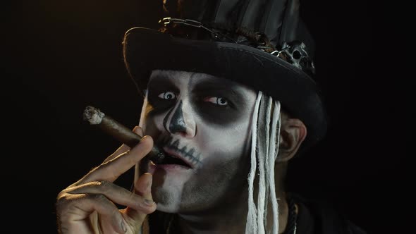 Scary Guy in Carnival Costume of Halloween Skeleton Smoking Cigar, Making Faces, Showing Tongue