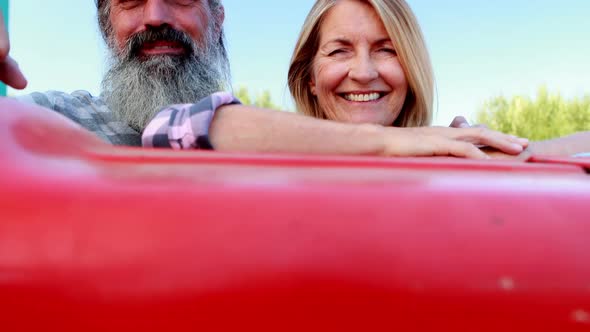Happy couple leaning on tractor in olive farm 4k