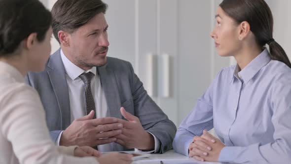 Male and Female Business Person having Serious Conversation in Office