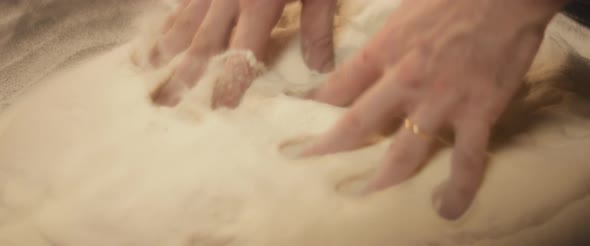 Close up of bakery chef kneading dough, making pizza with traditional italian recipe. Slow motion.