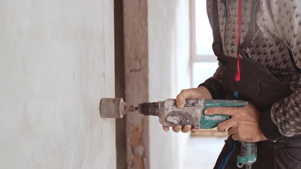 Fotage of Caucasian Male Worker Using Drill to Make Hole in Wall in Slowmotion