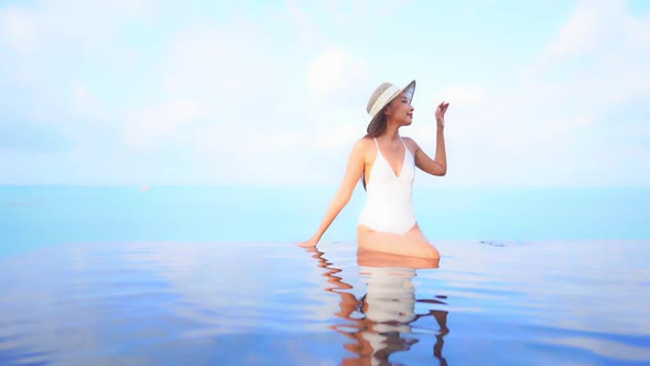 Young asian woman enjoy around outdoor swimming pool for leisure