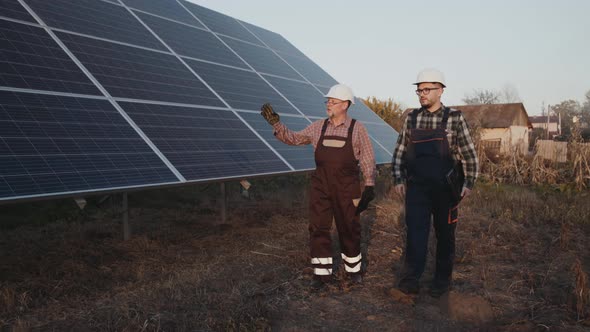 Two Factory Engineers Walking and Analyzing Construction of Solar Batteries