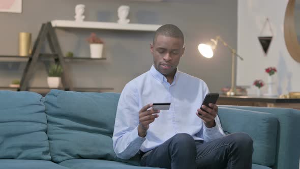 African Man Making Successful Online Payment on Smartphone