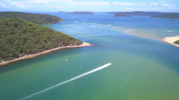 Beautiful epic aerial view of a speed boat passing the tropical island paradise with blue turquoise