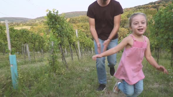 Slow motion shot of father and daughter running in vineyard