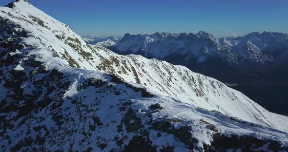 Aerial drone view of snow covered mountains in the winter.