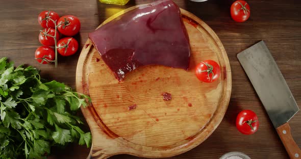 The Men's Hand Puts Pieces of Raw Liver on Cutting Board