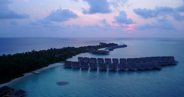 Daytime overhead copy space shot of a white sandy paradise beach and aqua blue water background in 4