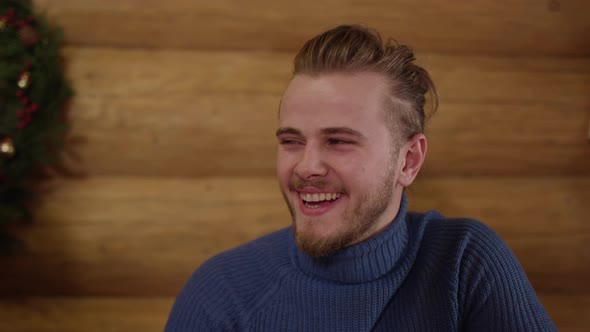 Young man with a beard laughing alt