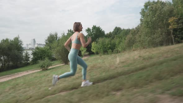 Slow Motion Shot Young Woman Running on the Hard Trail