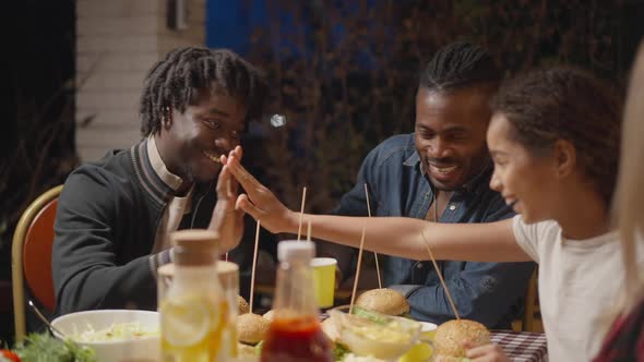 Portrait of Joyful African American Adult Brother and Teenage Sister Giving Highfive As Smiling