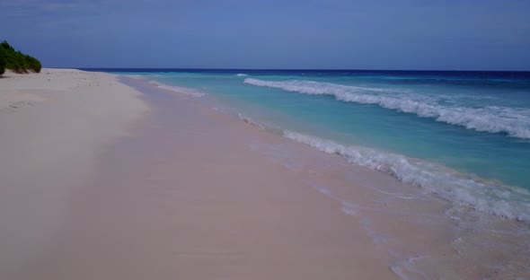 Daytime drone clean view of a summer white paradise sand beach and turquoise sea background in vibra