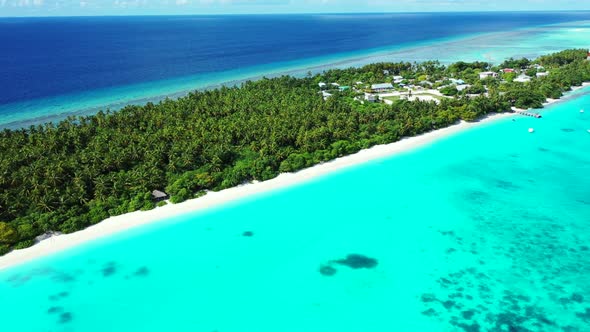 Aerial flying over nature of marine lagoon beach break by blue green sea with white sandy background