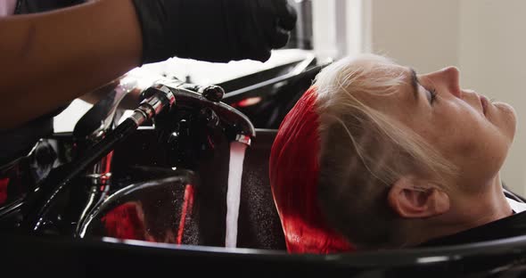 Side view woman having her hair washed by a hairdresser