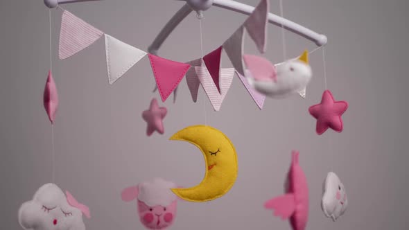 Baby Mobile with Pink Handstitched Animal and Bird Toys with Yellow Moon on White Wall Background