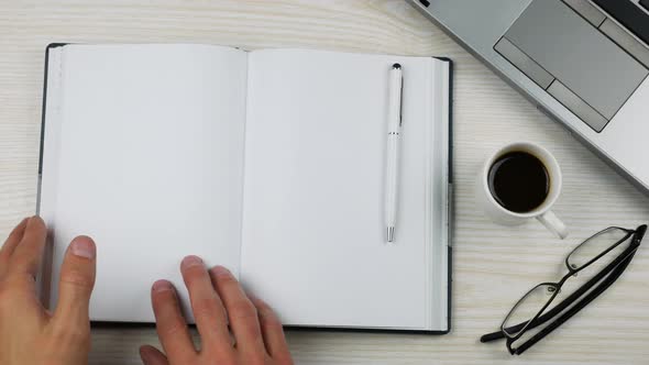 Top View Office Desk. Opening a Book on a Blank Page for Notes 