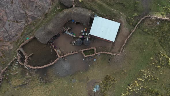 Aerial bird's eye view over inca terrace farms in Bolivian Andes at daytime. View of a small cottage