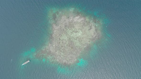 Aerial: Flying over coral reef turquoise water tropical island, scenic travel