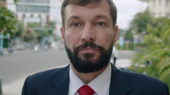 Business Man in an Expensive Suit in a Red Tie with a Handsome Bearded Senior Businessman Stands on