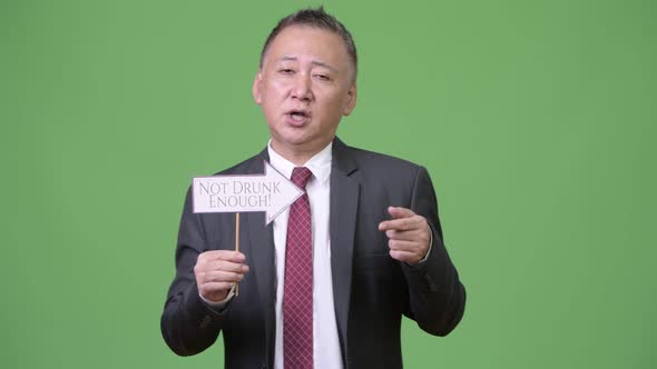 Mature Japanese Businessman Holding Paper Sign