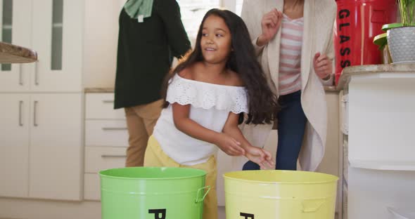 Hispanic parents and daughter teaching segregating plastic trash