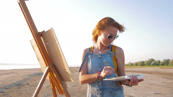 Young Woman Artist Painting Landscape in the Open Air on the Beach