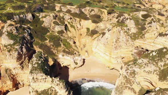 Washing waves on tranquil beach framed by cliffs and rock formations, Lagos , Algarve, Portugal