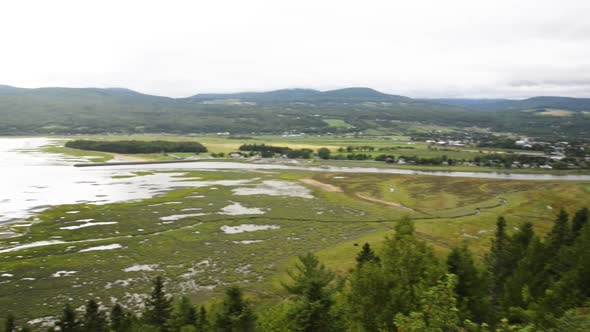 Pan across the scenic landscape of the Gaspe region of Quebec along the St. Lawrence River