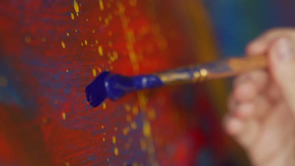 Closeup of a Female Artist's Hand Drawing with a Brush in Blue