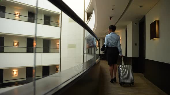 Elegant Businesswoman Walking Along Hotel Balcony