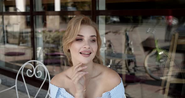 Sexy Girl Sitting In A Cafe On The Summer Terrace