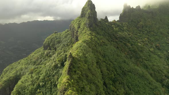 Aerial view flying over a mountain ridge covered by exuberant vegetation in Mo'orea island