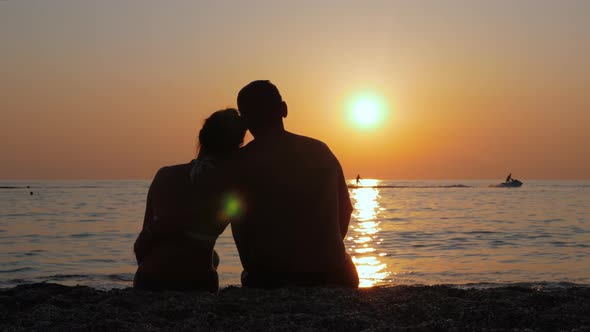 A Man with a Woman Watching a Colorful Sunset.