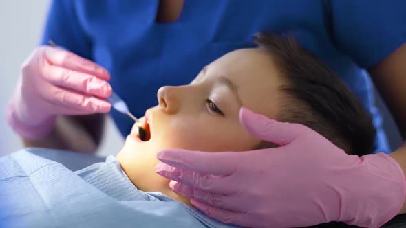 Female Dentist with Kid Patient at Dental Clinic